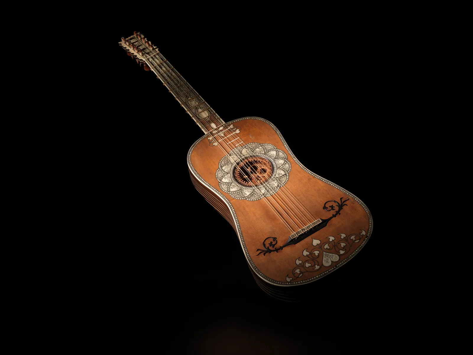 Baroque guitar with an inlaid body and rose, on black