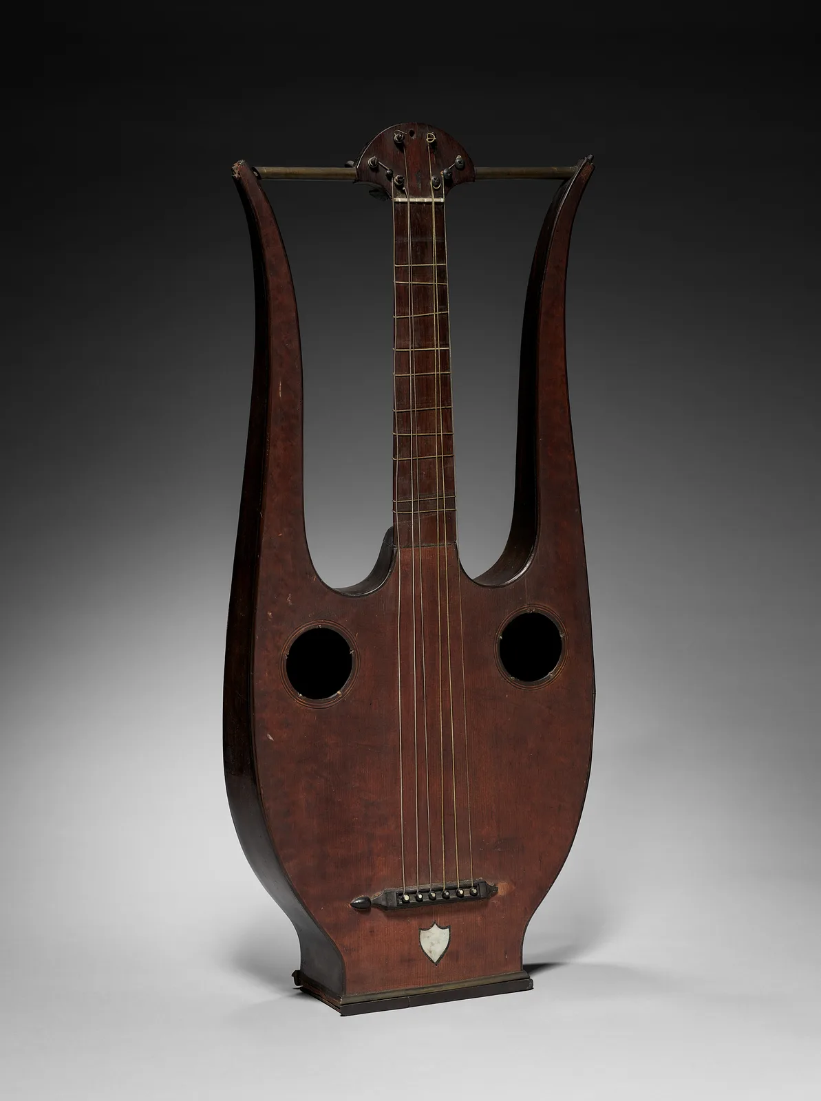 Lyre-guitar: a guitar neck and strings set between two curved lyre arms